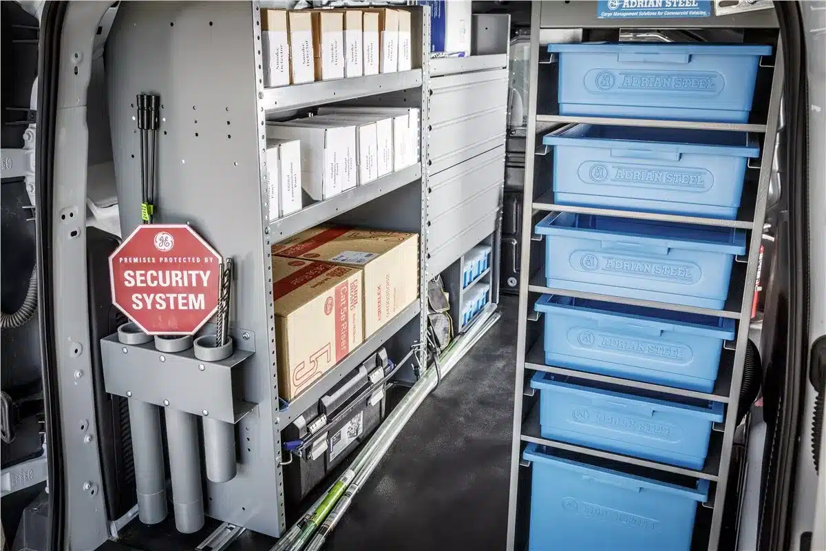 Interior of a 2026 commercial van featuring a security trade upfit with organized shelving and a wire reel rack