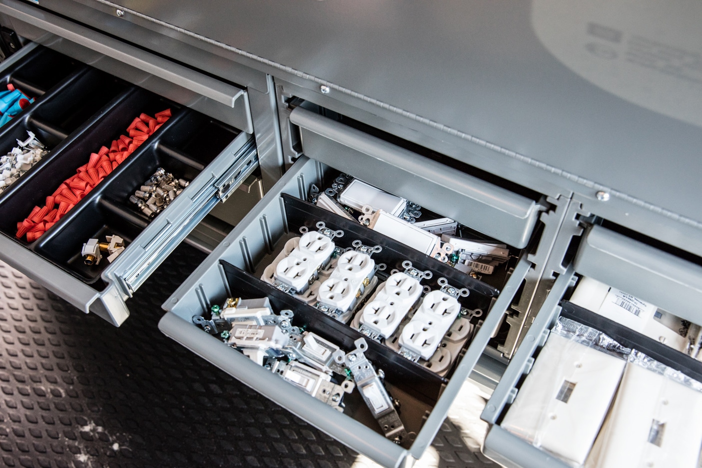 Commercial electrician van upfit featuring heavy-duty pull-out storage drawers and organized tool compartments for efficient mobile service operations